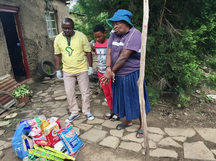 Street hawker Lindiwe Ngubane and Sbongakonke Ngubane receive a grocery donation at her home from Sibongumusa Zuma.