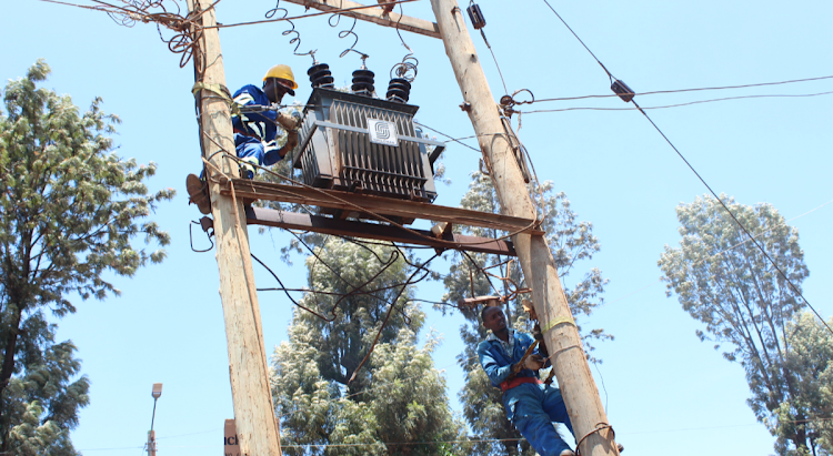 Kenya Power workers install a brand new transformer at Kiawaihiga shopping centre after vandalism of the former one on April 6, 2022.