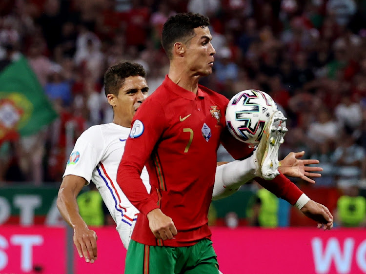 Portugal's Cristiano Ronaldo in action with France's Raphael Varane