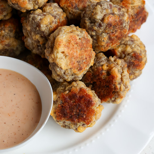 A tasty and moist Sausage Ball Recipe made with minced onion, garlic, and sharp cheddar. Prepped and in the oven in less than fifteen minutes. 