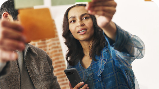 Woman holding Android phone in discussion with man holding an Android tablet