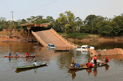 Locals and rescue workers navigate on boats at Curuca river after a bridge collapsed in BR-319 road in Careiro da Varzea, near Manaus, Brazil, September 28, 2022. 