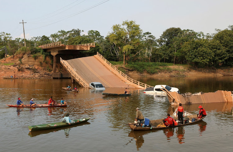 Locals and rescue workers navigate on boats at Curuca river after a bridge collapsed in BR-319 road in Careiro da Varzea, near Manaus, Brazil, September 28, 2022.