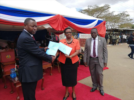 Samburu County governor Moses Lenolkulal, left, presenting a contract to tourism investors on Thursday 21 in Maralal town.