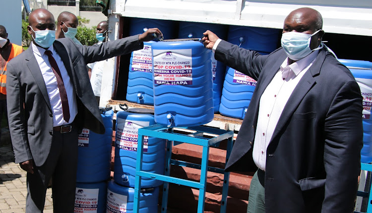 Bomet Governor Hillary Barchok receives water tanks from George Williamson Tea general manager Ismael sang