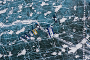 An aerial view shows hoverboats on the ice of lake Baikal near the village of Bolshoye Goloustnoye in Irkutsk region, Russia, March 8, 2021. Lake Baikal remains one of the world's cleanest fresh water reservoirs. But pollution and the growth of weeds are harming microorganisms, sponges and some molluscs that filter its waters. The Baikal pulp and paper mill and its sewage treatment facilities were closed seven years ago, but pollution has spread significantly since then, according to local media. That, some experts say, is because pollution left behind at the industrial site is draining into the lake. Picture taken with a drone. 