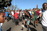 MOB JUSTICE: Children   and adults   in  KwaMashu take  to the streets  in protest following social media rumours that foreigners were  abducting children