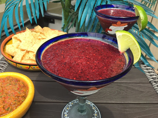 Couple glasses of margarita with salsa and chips