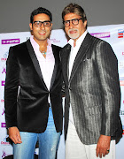 FILE PHOTO: Bollywood actors Amitabh Bachchan (R) and his son Abhishek Bachchan pose for a picture during a special screening of their movie 