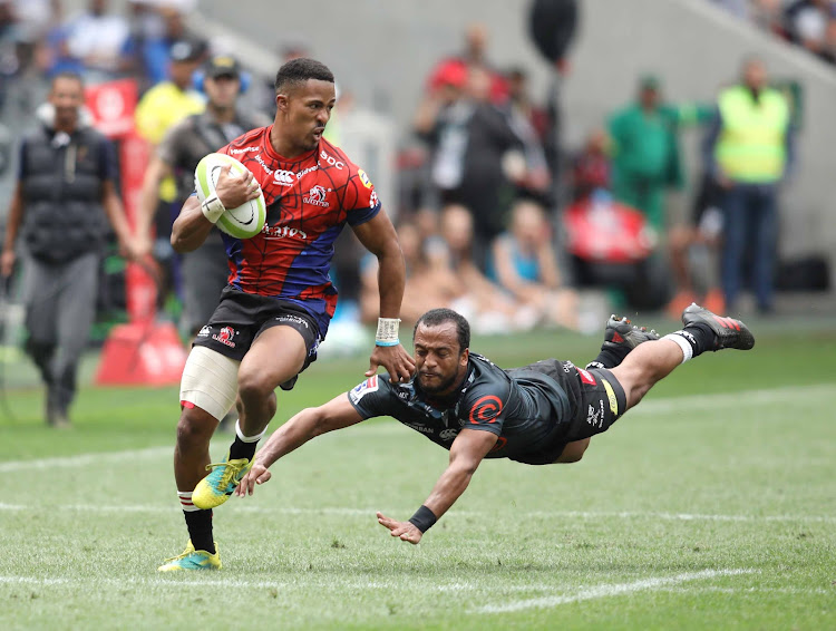 Lions Sylvian Mahuza on his way to the tryline with the Sharks' Rhyno Smith trying to tackle during their Super Hero Sunday Match at Cape Town Stadium on Sunday.