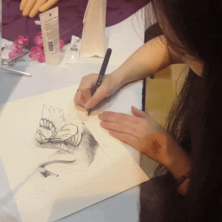 Naomi Hoang from NAOHOA Luxury Bespoke Tattoos, signing an art print. Cardiff Comic Con 2018.