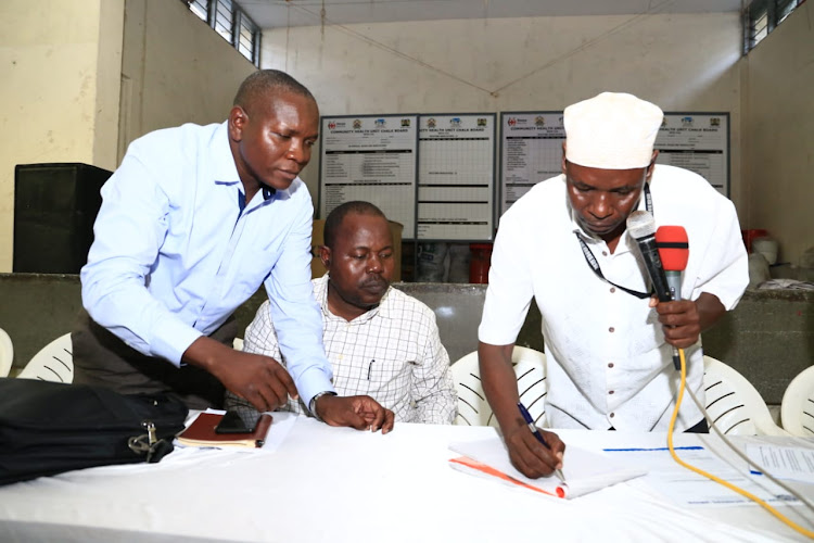 DWU chairman Mohamed Sheria signs a petition to oust Simon Sang as secretary general. Vice chairman Gunda Kaneno and deputy general secretary Anthony Odero look on at Koblenz Hall on Thursday.