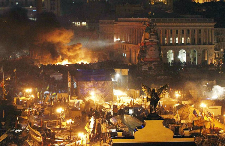 Smoke rises above burning barricades at Independence Square during anti-government protests in Kiev on February 20, 2014.