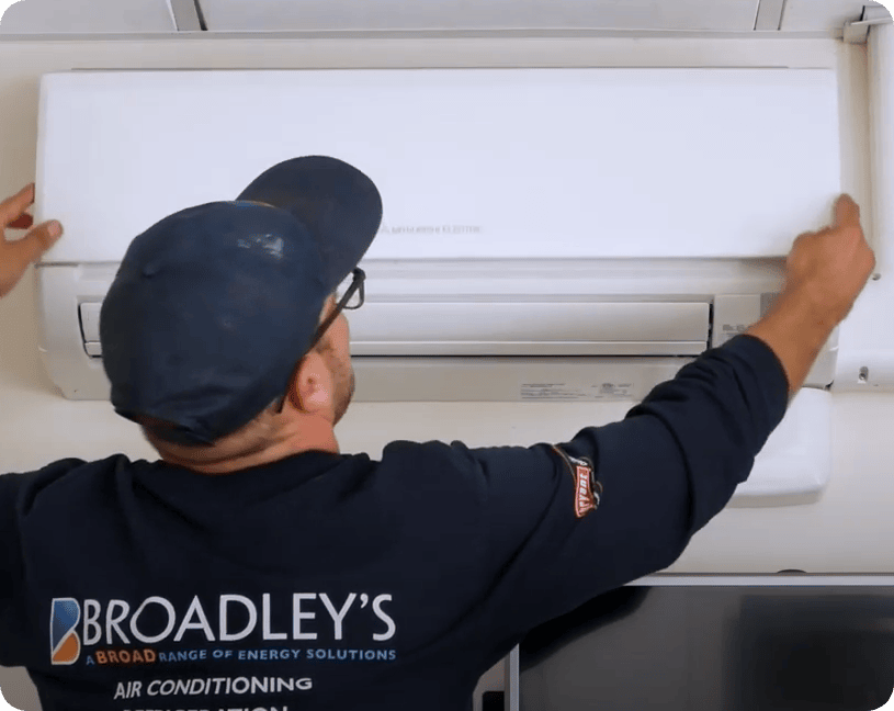 Broadley's tech removing a Mitsubishi Ductless Mini-Split cover panel. 