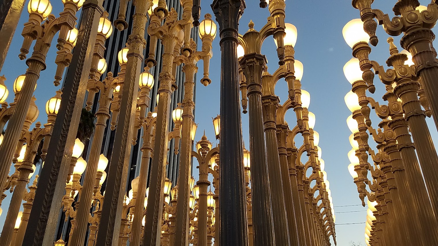 One of the most famous and free (since it is an outdoor sculpture) art you can see in the park at LACMA is the iconic Urban Lights. Created by Chris Burden, it is made of 202 restored street lamps in various styles based on where they were from (most are from southern California and some from Portland Oregon too!). The lamps are painted grey and assembled in a grid, and are solar powered and become lit in the evening.