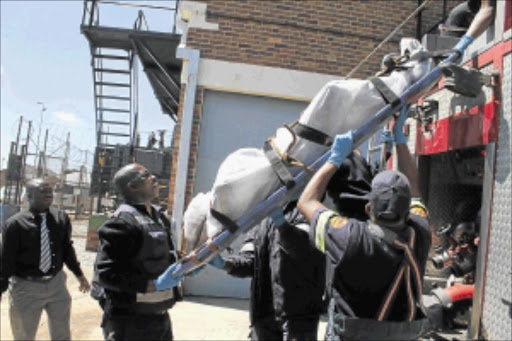 CHAOS: The body of an unidentified man is removed from the Roodepoort substation after the alleged cable thief was electrocuted. The entire Roodepoort area was left without power. PHOTO: BAFANA MAHLANGU