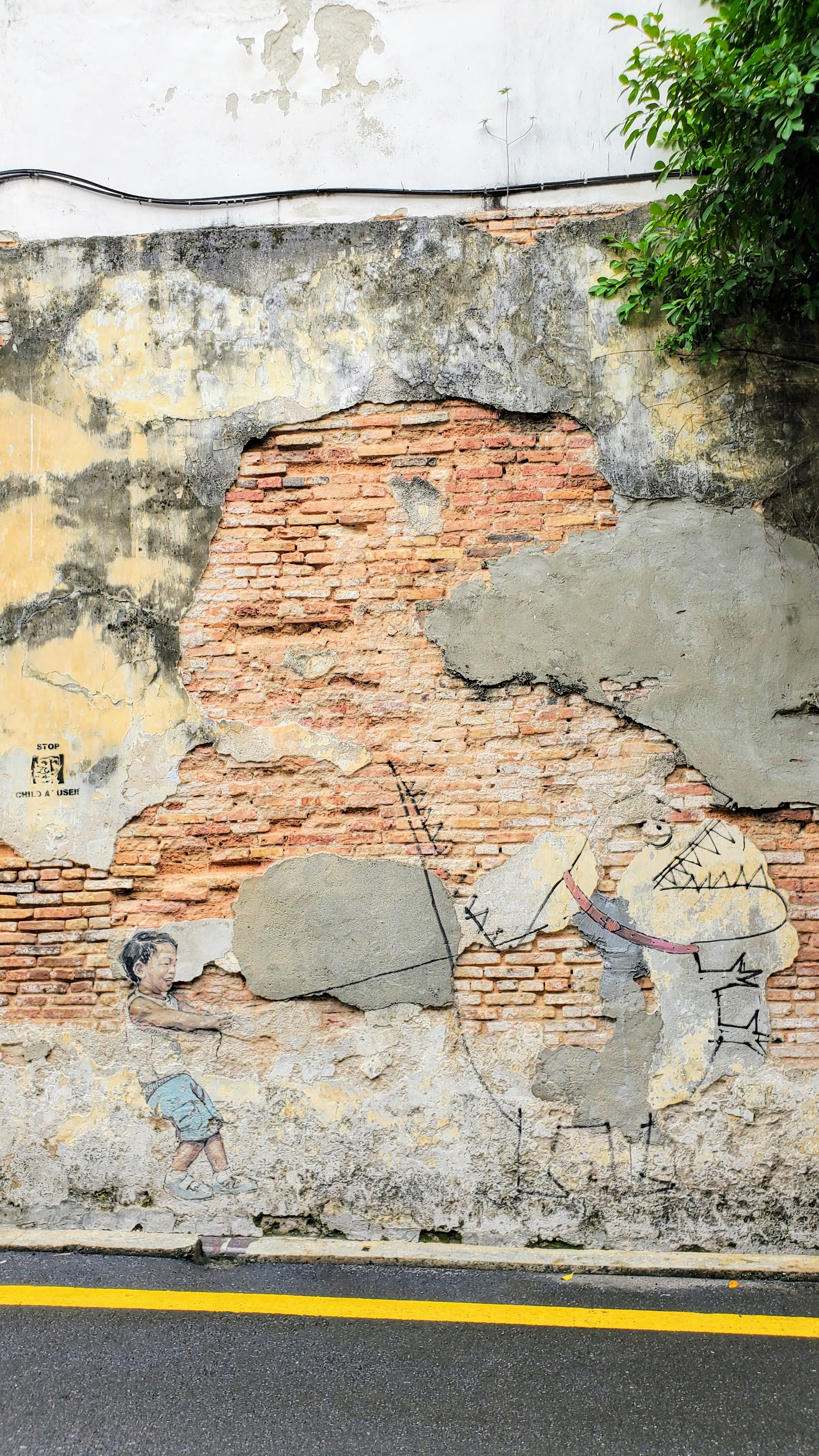 Tips on visiting George Town Street Art: the most famous street art are the ones from Ernest Zacharevic commissioned as part of a Mirrors George Town street art initiative and which are now considered iconic to George Town. This is Little Boy with a Pet Dinosaur