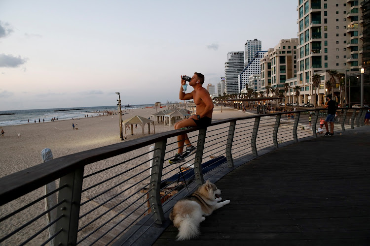 A man drinks by the shore after Israel imposed a second nationwide coronavirus lockdown amid a rise in infections, in Tel Aviv.