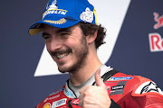 Francesco Bagnaia celebrates pole position at the end of the MotoGP qualifying session. 