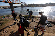 Migrants walk along the banks of the Rio Grande river before crossing in an attempt to seek asylum into the US, as seen from Piedras Negras, Mexico, on September 29 2023. File photo.