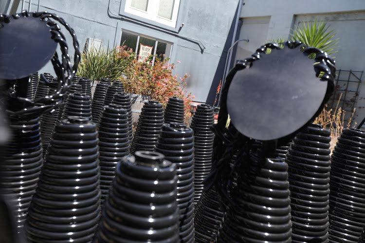 The "bodies" of ancestor statues for an upcoming exhibit by sculptor Dana King are seen in her courtyard while a "Black Lives Matter" sign is seen in the window in Oakland, California, US June 10, 2021.