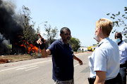 Zeta Laboratories manager Nikesh Singh speaks to a member of the metro police at the scene of the fire.