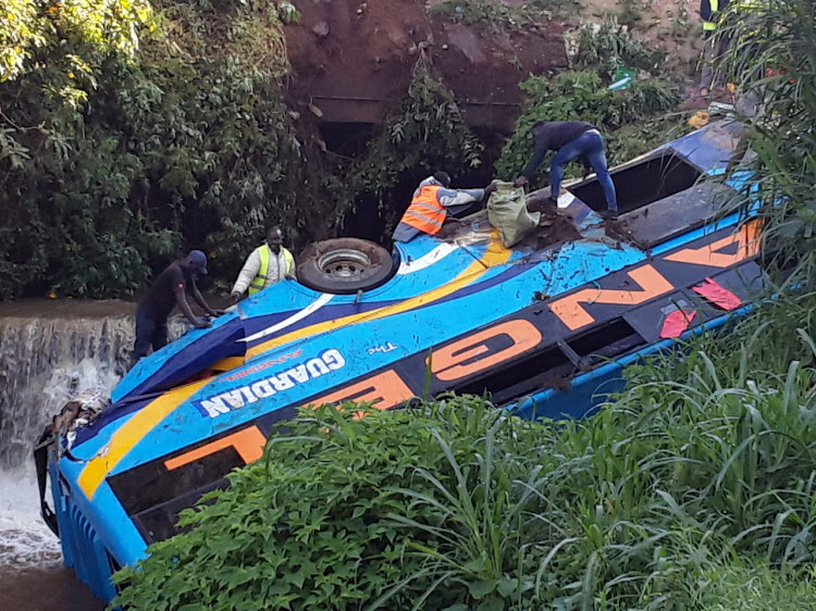 Rescues atop the bus to pull passengers trapped in the wreck after a canter hit it sending it down the cliff into river Nyambera in Kisii on Saturday morning (PHOTO BY MAGATI OBEBO)