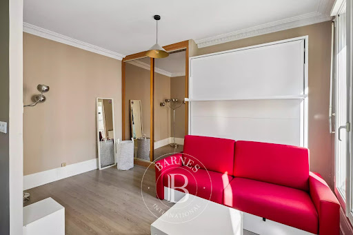 Red sofa, mirrored wall and murphy bed - Apartment / penthouse purchase in Paris 7ème, 1 room