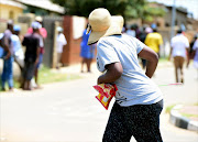 Residents carry goods which they took from a looted shop owned by foreign nationals on January 21, 2015 in Soweto, South Africa. The looting of shops owned by foreign nationals has spread to other areas in Soweto following an incident where a shop owner shot dead a teenage boy who attempted to rob his shop on Monday.