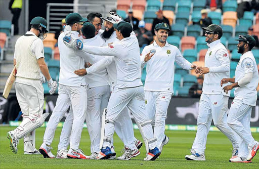 SIX OF THE BEST: Proteas paceman Kyle Abbott, centre, celebrates his wicket of Australia’s batsman, Adam Voges, with teammates on the fourth day's play of the second Test match between the sides in Hobart yesterday. Abbott finished with six wickets for 77 as the Proteas romped to an innings and 80 runs victory Picture: AFP