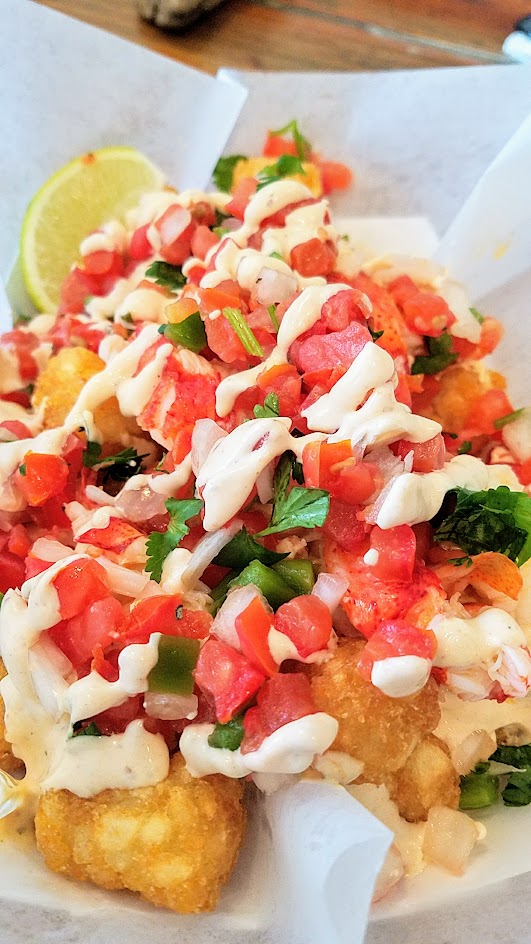 Cousins Maine Lobster in West Hollywood in Los Angeles, California, the only brick and mortar restaurant location besides the food trucks This is their Lobster Tots, tater tots with warmed Maine lobster, cilantro lime sauce, and pico de gallo.