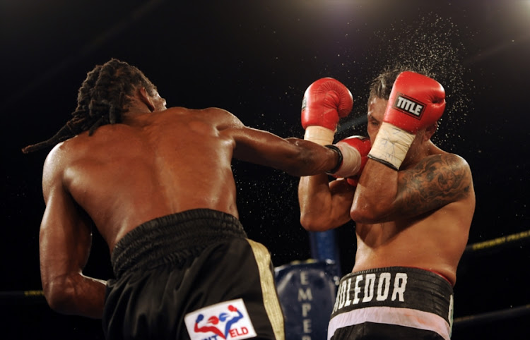 South Africa's Thulani Mbenge throws a punch past the defenses of Mexican boxer Diego Cruz during the vacant WBC international welterweight title at the Palace Pandemonium boxing event at Emporers Palace on March 03 2018 in Johannesburg, South Africa.