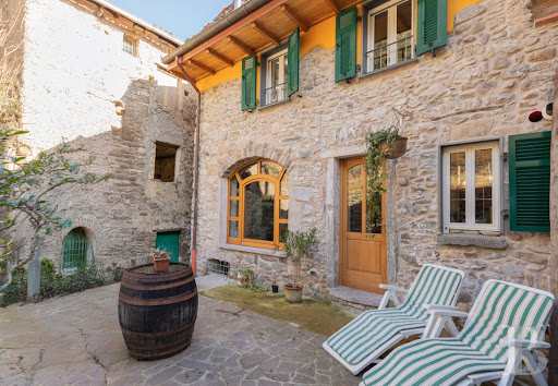 Luxury house for sale in Pignone (Italy) - Paved courtyard with barrel and chairs