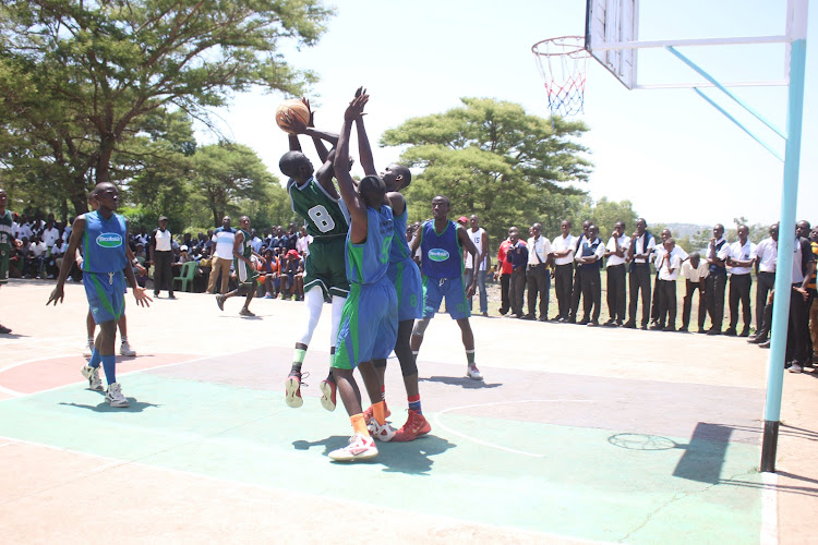 Maseno School captain Aduol Dennis (in green) attempt to shoot against Agoro Sare during the Nyanza region secondary schools basketball finals.