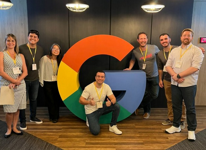 Equipe da Woof em frente ao logo do Google
