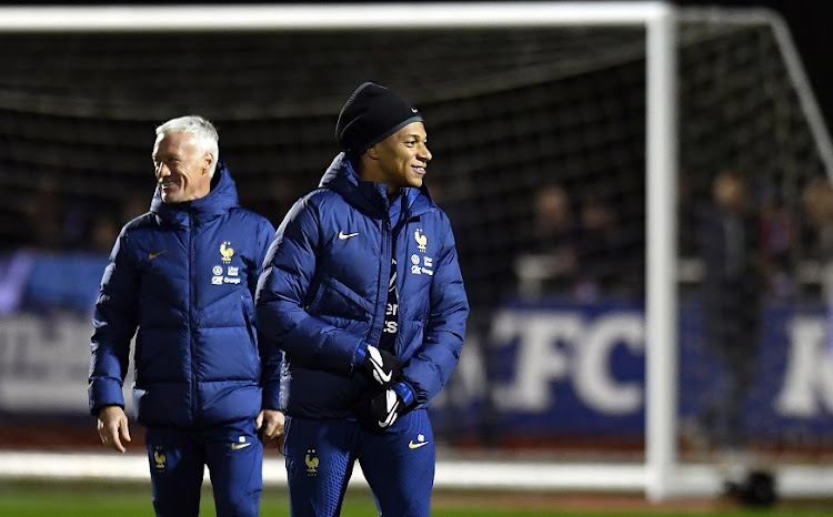 Kylian Mbappe speaks with coach Didier Deschamps during a Team France training session at Centre National du Football in Etival-Clairefontaine, France on November 15 2022.