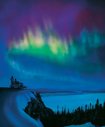 Snowmobile-under-Northern-Lights-Labrador.jpg - Outdoors lovers pause in their snowmobile to watch the Northern Lights in Labrador. 