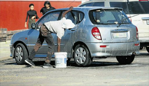 NOT A DESIGNATED SPOT: Car washers on the East London Esplanade say metro law enforcers take away their soap and buckets Picture: MICHAEL PINYANA