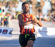 Gauteng's Precious Mashele stops his watch as he breaks the tape to claim his first national half marathon title at the Nelson Mandela Bay Half Marathon incorporating the SA Half Marathon Championships in Gqeberha on Saturday morning. 