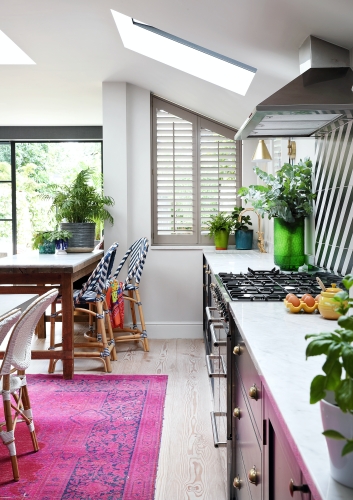 This fuschia pink rug adds a punch of colour, while pairing perfectly with the colour pops throughout this kitchen.