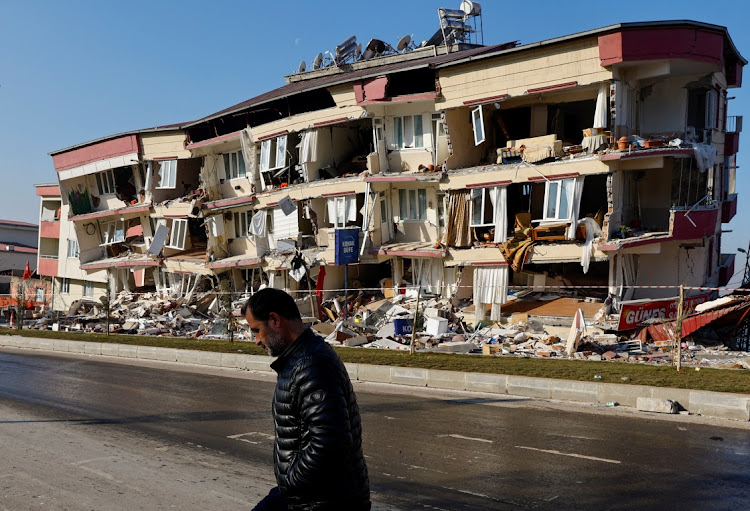 A man walks past a damaged building in the aftermath of a deadly earthquake in Kahramanmaras, Turkey, on February 13 2023. Picture: REUTERS/SUHAIB SALEM