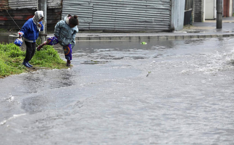 Children playing near a flooded road in Cape Town. File photo.