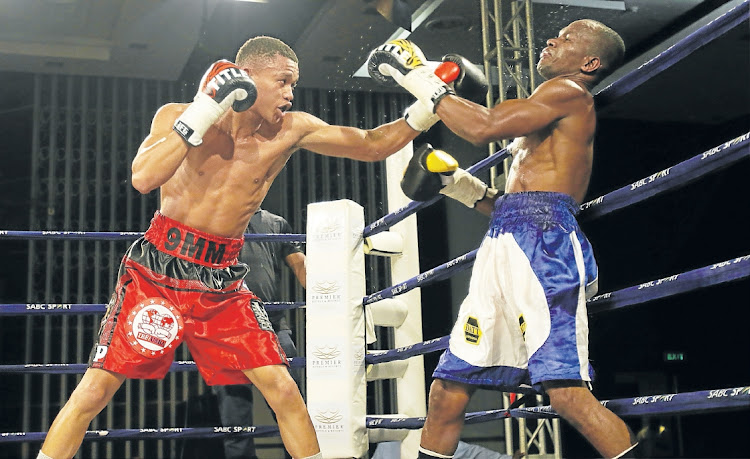 Ludumo Lamati of SA has Luis Mendeles of Colombia against the ropes during their vacant IBF intercontinental junior featherweight title fight.