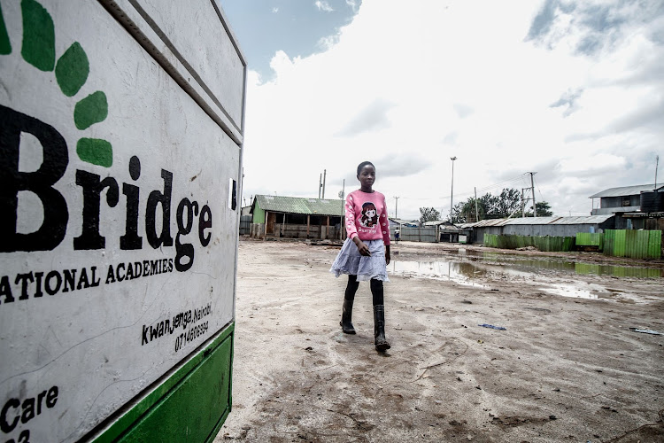 Florence Kwamboka leaves the school gate at Bridge International School in Mukuru kwa Njenga on March 30.