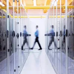 A member of the Chronicle team walks between a row of servers in a server farm