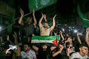 Palestinians celebrate in the streets after a ceasefire, in the southern Gaza Strip on May 21, 2021. 