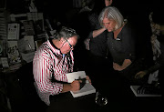 Jacques Pauw signs copies of his book 'The President's Keepers' despite a power outage during the launch at Exclusive Books in Hyde Park Shopping Centre.