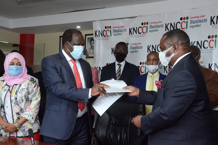 Council of Governors chairman Wycliffe Oparanya exchanges the MoU document with Kenya National Chamber of Commerce and Industry president Richard Ngatia at KNCCI head office in Nairobi yesterday.