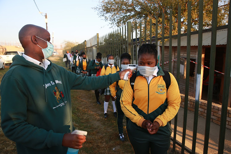 Learners at Olivenhoutbosch secondary school queue as their tempreture levels are screened before they enter the school premises in June 8 2020.