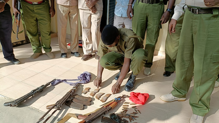 A Police officer displays some of the guns and ammunitions recovered in the outskirts of Garissa town on March 2, 2022.